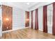 Spacious bedroom with wood-look floors, accent wall panels, and large windows with privacy curtains at 4462 Dandelion Ln, Atlanta, GA 30342