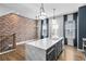 Modern kitchen island with marble countertop and stainless steel appliances, complemented by exposed brick wall at 4462 Dandelion Ln, Atlanta, GA 30342