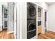 Convenient laundry area with stacked washer and dryer, built in storage, and stylish birch-patterned curtain at 4462 Dandelion Ln, Atlanta, GA 30342
