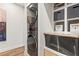 Modern laundry area featuring sleek, stacked washer and dryer with adjacent shelves and wood accents at 4462 Dandelion Ln, Atlanta, GA 30342