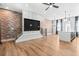 Open-concept living space with brick accent walls and hardwood floors leading to modern kitchen at 4462 Dandelion Ln, Atlanta, GA 30342