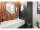 Elegant powder room with wood accent wall, round mirror, and modern fixtures at 4462 Dandelion Ln, Atlanta, GA 30342