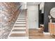 Stylish staircase featuring a brick accent wall, wood handrail, and modern finishes at 4462 Dandelion Ln, Atlanta, GA 30342