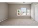 Bright bedroom featuring neutral carpeting, trim, walls and a bank of windows allowing natural light at 4630 Roseman Trl, Cumming, GA 30040