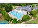 Aerial view featuring a large community pool with ample seating, surrounded by manicured landscaping and mature trees at 4630 Roseman Trl, Cumming, GA 30040