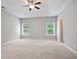 Spacious primary bedroom featuring neutral walls, plush carpeting, and plenty of natural light from two windows at 4630 Roseman Trl, Cumming, GA 30040