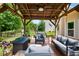 Covered patio with plush outdoor seating, fire pit, and manicured lawn and garden views at 492 Thorn Creek Way, Dallas, GA 30157