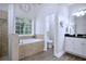 Bright bathroom with a soaking tub, separate shower, and modern fixtures, offering a spa-like experience at 492 Thorn Creek Way, Dallas, GA 30157