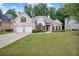 Lovely white brick home featuring a well-manicured lawn, double garage, and classic architectural details at 492 Thorn Creek Way, Dallas, GA 30157