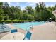 Community pool with lounge chairs and picnic area surrounded by trees at 492 Thorn Creek Way, Dallas, GA 30157