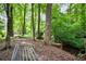 Bench overlooking a creek and lush, mature trees create a serene, private backyard oasis at 492 Thorn Creek Way, Dallas, GA 30157