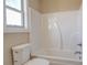 Bright white bathroom featuring a standard-size bathtub and toilet at 9183 Golfview Cir, Covington, GA 30014
