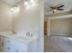 Bright bathroom featuring double sinks and an open doorway to a large bedroom at 9183 Golfview Cir, Covington, GA 30014