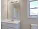 Bright bathroom vanity featuring a large mirror and a view to the outside at 9183 Golfview Cir, Covington, GA 30014