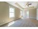Bright bedroom featuring a trey ceiling with fan, neutral walls, and bright windows at 9183 Golfview Cir, Covington, GA 30014