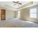 Spacious bedroom featuring plush carpet, a trey ceiling with fan, and bright windows at 9183 Golfview Cir, Covington, GA 30014