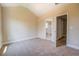 A carpeted bedroom boasts neutral walls, trim, and an attached bathroom, offering comfort and convenience at 9183 Golfview Cir, Covington, GA 30014