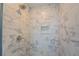 Close up of a shower featuring marble-look tile and a built-in niche at 9183 Golfview Cir, Covington, GA 30014