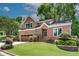 Charming two-story brick home with lush landscaping, a two-car garage, and a well-manicured lawn at 3007 Frazier Ct, Decatur, GA 30033
