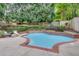 Backyard showcasing a uniquely shaped in-ground pool surrounded by brick and lush greenery at 3007 Frazier Ct, Decatur, GA 30033