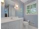 Bathroom with blue wallpaper, white cabinets, and a window with shutters at 3999 Saint Clair Ne Ct, Brookhaven, GA 30319