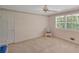 Bright bedroom featuring neutral walls, carpet, a ceiling fan, and natural light from a large window at 3999 Saint Clair Ne Ct, Brookhaven, GA 30319