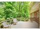 View of the deck with two white chairs surrounded by green trees at 3999 Saint Clair Ne Ct, Brookhaven, GA 30319