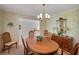 Formal dining room with traditional chandelier, large wooden table, and charming wallpaper, adjacent to living area at 3999 Saint Clair Ne Ct, Brookhaven, GA 30319