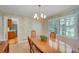 Formal dining room with traditional chandelier, large wooden table, and charming wallpaper, perfect for Gathering gatherings at 3999 Saint Clair Ne Ct, Brookhaven, GA 30319