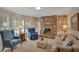 Comfortable living room with brick fireplace, built-in shelving, and natural light from large windows at 3999 Saint Clair Ne Ct, Brookhaven, GA 30319