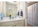 Bright bathroom features a white vanity with a marble countertop and a shower with striped curtain at 6140 Stillwood Ln, Cumming, GA 30041