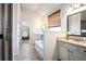 Bright bathroom with separate vanities, garden tub, tiled floors and open doorway at 6140 Stillwood Ln, Cumming, GA 30041