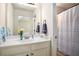 Bright bathroom featuring a white vanity, framed mirror and shower with a striped curtain at 6140 Stillwood Ln, Cumming, GA 30041