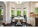 Cozy breakfast nook with bay window, dark hardwood floors, and view of wooded backyard at 6140 Stillwood Ln, Cumming, GA 30041