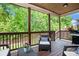 Relaxing covered porch with comfortable seating overlooking a lush, green backyard at 6140 Stillwood Ln, Cumming, GA 30041