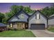 Charming two-story home with a well-manicured lawn, a gray garage door, and beautiful landscaping at 6140 Stillwood Ln, Cumming, GA 30041