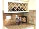 Charming kitchen counter with unique brick backsplash and stylish wine storage at 6140 Stillwood Ln, Cumming, GA 30041