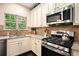 Close-up of kitchen features stainless steel appliances and granite countertops at 6140 Stillwood Ln, Cumming, GA 30041