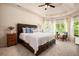 Spacious primary bedroom with a tray ceiling, large windows, and a luxurious king-size bed at 6140 Stillwood Ln, Cumming, GA 30041