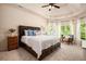 Spacious bedroom featuring a tray ceiling, a large bed, and natural light at 6140 Stillwood Ln, Cumming, GA 30041