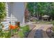 Landscaped backyard featuring a stone walkway, wooden deck, water feature, and mature trees at 122 Griffin Way, Canton, GA 30115