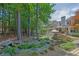 Expansive backyard with lush landscaping, a pond, mature trees, and a view of the rear of the home at 122 Griffin Way, Canton, GA 30115