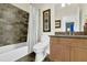 Bathroom with tub, shower, decorative tile wall, vanity with double sinks, and stone countertops at 122 Griffin Way, Canton, GA 30115