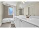 Well-lit bathroom with gray tiles, white vanity, shower and a decorative stained glass window at 122 Griffin Way, Canton, GA 30115