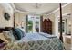 Well lit bedroom with a patterned bedspread, french doors, and a nice antique dresser at 122 Griffin Way, Canton, GA 30115