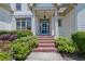 Inviting front entrance with brick steps, manicured bushes, and a classic blue door with wreath at 122 Griffin Way, Canton, GA 30115