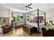Bedroom showcasing a four-poster bed, tray ceilings, hardwood floors, and relaxing sitting area at 122 Griffin Way, Canton, GA 30115