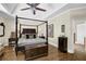 Bedroom displaying a four-poster bed, tray ceilings, hardwood floors, and elegant furnishings at 122 Griffin Way, Canton, GA 30115