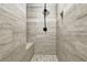 Walk-in shower boasts stone-look tile walls, pebble floor, built-in bench and niche, with black shower fixture at 122 Griffin Way, Canton, GA 30115