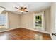 Sunlit bedroom with hardwood floors, a ceiling fan, and two windows offering ample natural light and a view to the yard at 166 Martha Ave, Atlanta, GA 30317
